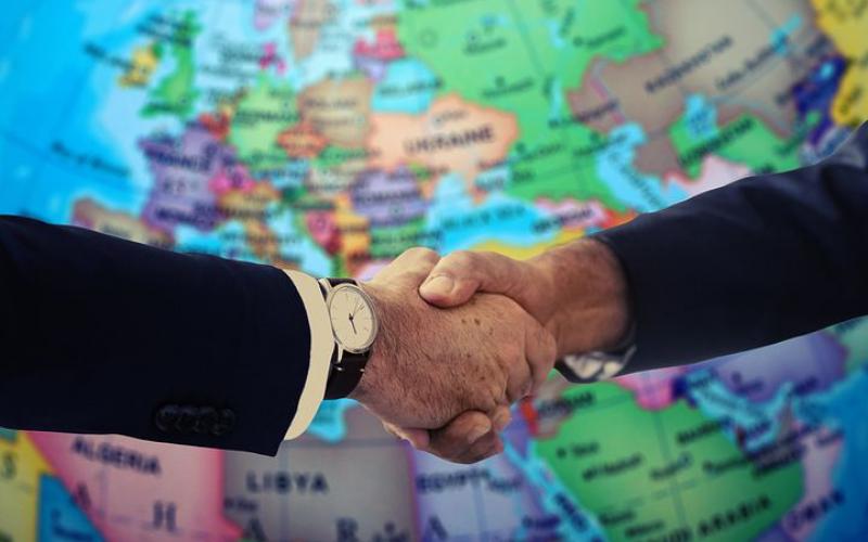 Poignée de main devant une carte du monde symbolisant un accord international.